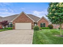 Charming brick home with a well-maintained lawn and a two-car garage on a sunny day at 4857 W Congress Cv, New Palestine, IN 46163