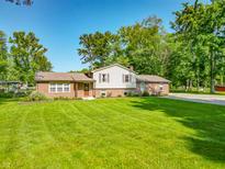 Charming brick home featuring a well-manicured lawn and beautiful landscaping at 6602 S 400 W, Columbus, IN 47201