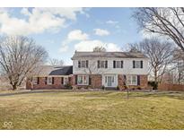 Charming two-story home with a brick and white facade and a well-manicured lawn at 8825 Dunsmuir Dr, Indianapolis, IN 46260