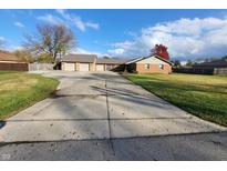 Traditional brick home with a long driveway and a three-car garage in a suburban neighborhood at 934 S 300 E, Anderson, IN 46017
