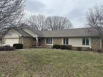 Charming stone home featuring a two-car garage and inviting front yard with mature landscaping and a cozy porch at 1400 Hillside Dr, Franklin, IN 46131