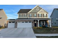 Charming two-story home with gray siding, stone accents, a three-car garage, and a well-manicured lawn at 19171 Foley Dr, Westfield, IN 46074