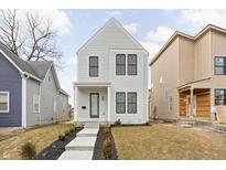 Charming two-story home with light gray siding, black window frames and a well-manicured front yard at 2052 Bellefontaine St, Indianapolis, IN 46202
