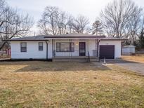 Charming home with a covered front porch, attached garage and well-maintained landscaping at 2219 W 59Th St, Indianapolis, IN 46228