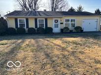 Charming one-story home featuring a front-facing garage, well-maintained lawn and mature landscaping at 2685 Streamside Dr, Columbus, IN 47203