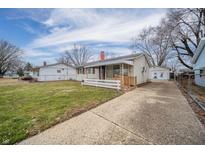 Charming single-story home with a front yard, long driveway, and a detached garage at 2821 Dakota Dr, Anderson, IN 46012