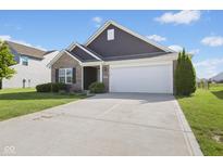 Charming home with a two-car garage, brick accents, and a well-maintained lawn and landscaping at 4236 Stubbington Ln, Indianapolis, IN 46239