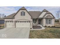 Charming brick home featuring a three-car garage, manicured lawn, and inviting front porch at 4268 Winners Cir, Bargersville, IN 46106