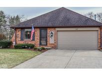Charming brick home with a two-car garage and well-maintained front lawn and an American flag at 447 Eagle Crest Dr, Brownsburg, IN 46112