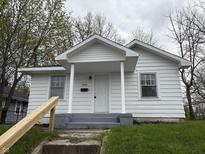 Charming white one-story home featuring a covered front porch and gray steps at 605 W 10Th St, Muncie, IN 47302