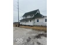 White two-story home features a green roof, complemented by a gravel driveway and minimal landscaping at 756 S State Road 13, Lapel, IN 46051