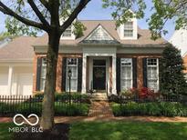Charming brick home featuring a well-maintained lawn, black shutters and an inviting entryway with a wreath on the front door at 8044 Clymer Ln, Indianapolis, IN 46250