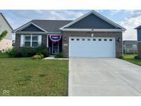 Charming one-story home featuring a well-manicured lawn and attached two car garage at 958 Mesa Ln, Bargersville, IN 46106