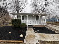 Charming one-story home with a welcoming front porch, neat landscaping, and a walkway to the front door at 1007 Denison St, Indianapolis, IN 46241
