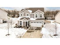 Charming two-story home featuring a two-car garage and a neatly maintained front yard covered in winter snow at 1118 Sunset Blvd, Avon, IN 46123