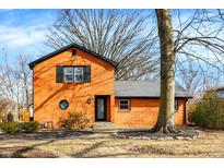 Charming brick home with a black roof, black trim and a well-maintained front yard at 129 N Sadlier Dr, Indianapolis, IN 46219