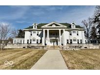 Stately home featuring a grand facade with columns and a symmetrical design at 1300 W University Ave, Muncie, IN 47303