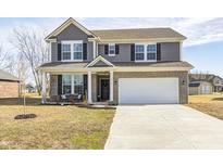 Charming two-story home features a brick and gray siding exterior, a welcoming front porch, and a two-car garage at 13115 N Departure W Blvd, Camby, IN 46113