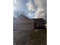 Charming single-story home featuring a brick facade, attached garage, and well-maintained lawn at 208 Monroe St, Indianapolis, IN 46229