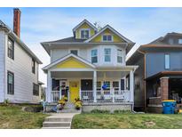 Charming two-story home with a welcoming front porch, swing, and colorful flower pots at 3145 N New Jersey St, Indianapolis, IN 46205