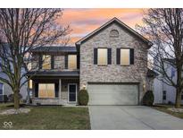 Two-story brick home with a two-car garage and a well-manicured lawn at sunset at 5546 W Vistaview Trl, McCordsville, IN 46055