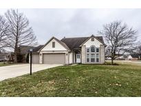 Charming two-story home with a large front yard, three-car garage and beautiful arch window at 8663 Woodbluff Ct, Indianapolis, IN 46234