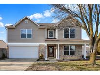 Charming two-story home with tan siding, brick accents, attached garage and well-maintained lawn at 970 Youngs Creek Dr, Franklin, IN 46131