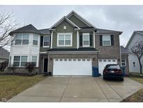 Two-story home with a two-car garage, brick and green siding, and a well-maintained front yard at 9993 Pepper Tree Ln, Noblesville, IN 46060