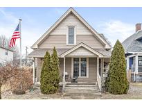 Charming home with a peaked roof, front porch, and American flag. Landscaped with shrubs and gravel at 116 W King St, Franklin, IN 46131