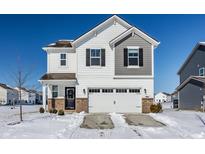 Charming two-story home with attached two car garage and well-maintained landscaping in winter at 11799 Winnower, Noblesville, IN 46060