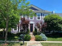 Charming two-story purple home featuring manicured landscaping and a welcoming front entrance at 12695 Vanderhorst St, Carmel, IN 46032