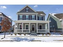 Charming two-story home with a welcoming front porch and manicured, snow-covered landscaping at 15576 Marsden Dr, Westfield, IN 46074