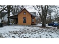 Exterior view of a quaint home with orange siding and red trim in a snowy landscape at 1621 Indiana Ave, Anderson, IN 46012