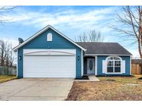 Charming blue home featuring a garage, well-manicured lawn and bright natural light shining through the front window at 169 Meadow Glen Dr, Avon, IN 46123