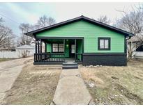 Charming single-story home boasts a covered front porch, a freshly painted exterior, and easy access to the front walkway at 1820 N Dequincy St, Indianapolis, IN 46218