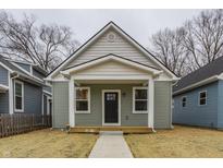 Charming single-story home with a covered porch, manicured lawn, and inviting curb appeal on an overcast day at 2193 N Dexter St, Indianapolis, IN 46202