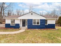 Charming one-story home with blue and white accents, landscaped yard and inviting front entrance at 3095 W 69Th St, Indianapolis, IN 46268