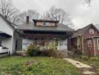 Two-story house with a chimney and partial siding, appearing to be undergoing renovations or repairs at 3178 Graceland Ave, Indianapolis, IN 46208