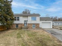 Charming two-story home featuring a brick and wood exterior, attached garage, and a well-manicured front yard at 5441 E 34Th St, Indianapolis, IN 46218