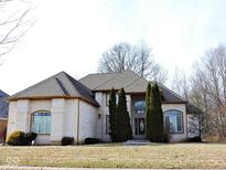 Charming brick home with mature trees and manicured landscaping adds welcoming curb appeal at 7874 Preservation Dr, Indianapolis, IN 46278