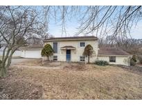 Charming split-level home featuring a blue front door and tidy landscaping at 10483 126Th St, Fishers, IN 46038