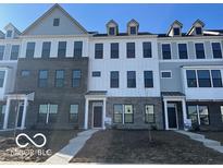 View of a modern two-story townhouse with varied brick and siding and a well-manicured front yard at 10954 Hanovarian St, Zionsville, IN 46077