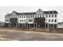 View of newly constructed townhomes with modern exteriors and landscaped yards at 10954 Hanovarian St, Zionsville, IN 46077