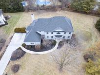 Aerial view of a luxurious two-story home with a well-manicured lawn, private driveway, and a glimpse of a pool at 12878 Mayfair Ln, Carmel, IN 46032