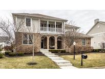 Charming two-story brick home with a covered front porch and well-manicured lawn at 2000 Haverford St, Carmel, IN 46032
