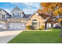 Charming brick home with a well-manicured lawn, mature tree, and attached two-car garage at 2148 Heathrow Ct, Brownsburg, IN 46112