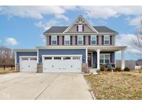Charming two-story home featuring a three-car garage, blue and gray siding and a cozy front porch at 2627 Chalbury Dr, Plainfield, IN 46168