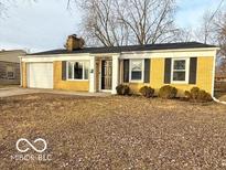 Charming single-story home with a yellow brick facade, attached garage, and well-maintained lawn at 3656 Allison Ave, Indianapolis, IN 46224