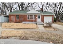 Charming brick home with a green roof, front lawn, attached garage, and inviting entryway at 40 Lincoln Dr, Brownsburg, IN 46112
