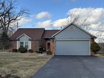 Charming single-story home featuring brick and vinyl siding, a two-car garage, and a well-maintained front yard at 5550 Crystal Bay W Dr, Plainfield, IN 46168